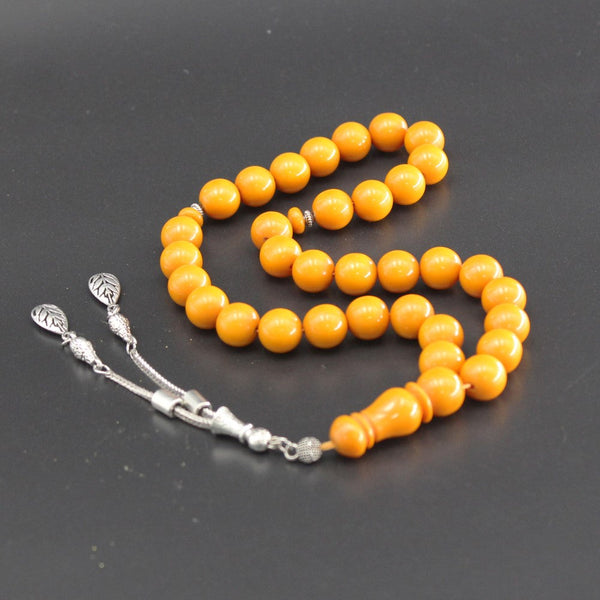 A musky sandalous rosary in a strong amber color, a medium bead woven with a strong fluorocarbon thread and a crochet made of a mixture of antimony and metal.